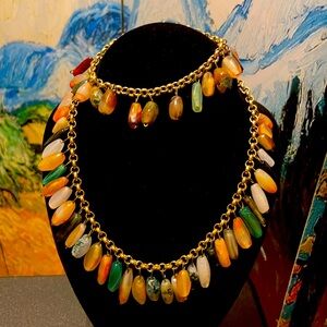 Handmade necklace and bracelet with multicolored beads on gold-colored chain